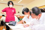 自己について生徒に考えさせようと授業を行う長曽我部准教授（左）