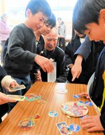 祖父母と触れ合いながらメンコを楽しむ児童＝７日、香美町香住区の香住小