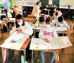 一つ一つの記事を丁寧に読み込む児童たち＝崎津小
