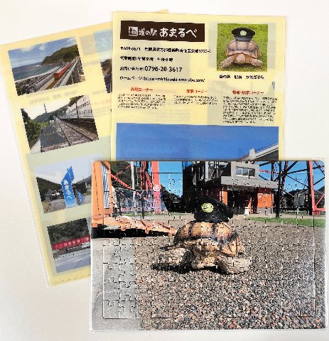 駅長「かめだそら」や余部橋りょうがプリントされたジクソーパズルとクリアファイル