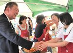 総裁選への出馬表明後、訪れた地元八頭町の祭りで握手を求められる石破氏＝２４日、八頭町宮谷の郡家運動場