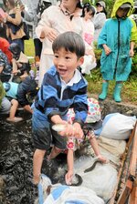 水路で魚のつかみ取り体験を楽しむ子ども