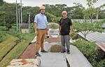 　車両番号「サシ４８１―４８」の食堂車の上に立つ岩谷淳平さん（左）と山崎賢一さん＝２０２４年８月、盛岡市