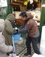 能登半島地震の被災者に「復興常備食」を配る北條誠一さん（右）＝石川県輪島市（徳島県キッチンカー協会提供）