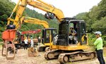 「グラップル」を取り付けたパワーショベルの操作を体験する生徒＝１日、日南町新屋