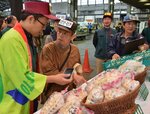 今年の出荷量などをイベント担当者に聞く市場関係者（中央）＝２９日、東京都大田区の都中央卸売市場大田市場