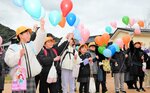 【大空彩る風船】閉校式終了後、校庭に繰り出して風船を飛ばす児童。色とりどりの風船が大空を彩った＝佐津小
