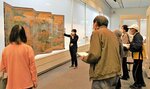 「曽我物語図屏風」の解説を聞く来館者＝鳥取市上町の市歴史博物館