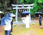 新築された鳥居の前に集まった住民ら