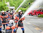 本番さながらに迅速な手際で消火作業を行う消防団員たち＝豊岡市城崎町湯島