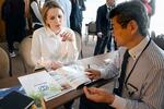 　６日、キーウで開かれた商談会で、メビオールの説明を聞くトマト生産加工企業の女性（共同）