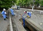 　水道管が破裂した現場で水抜きをする作業員＝１０日午後０時５７分、大阪市城東区