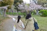 　次女の香奈さん（左）が初めてデートした公園で、手をつないで歩く岩山さん親子（いずれも仮名）＝２０２３年４月、兵庫県明石市