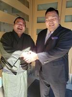 　音羽山部屋の玄関前で音羽山親方と握手する鋼（左）＝２０２４年２月、東京都墨田区の音羽山部屋