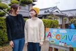　「ＡＳＯＶＩＶＡ！」（後方）の看板前で一緒に写真に納まる長村知愛（右）と吉元かおり＝２０２４年３月、大阪府河南町