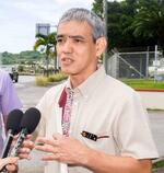 　記者団の取材に応じる沖縄県の又吉信基地対策統括監＝２０日午後、キャンプ瑞慶覧前
