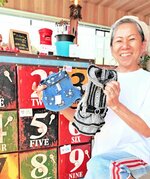 来店客から寄せられたぺット服を手にする田中さん＝三朝町大柿のドッグカフェＲＩＫＵとＭＵＧＩ