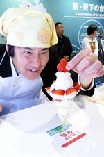 鳥取県産イチゴや大山乳業の乳製品を使ったパフェ作りに挑戦する井田記者＝１３日、大阪市此花区の夢洲
