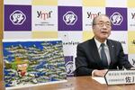 　記者会見する秋田魁新報社の佐川博之社長。左は漫画家矢口高雄さんの原画の複製＝２８日午後、秋田県庁