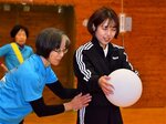 サーブの打ち方を教わる竹内記者（右）