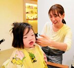 長く伸ばした髪を切ってもらう実結葉ちゃん（左）＝５月３１日、倉吉市越中町