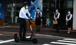 電動キックボードに試乗する空港職員＝１９日、鳥取市湖山町西４丁目の鳥取砂丘コナン空港