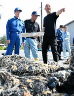 破損した漁具を前に漁業関係から被害状況の説明を受ける平井知事（左）＝１９日、湯梨浜町泊の泊漁港