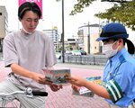 通行人らに自転車利用時のルールなどが書かれたチラシを配る署員（右）＝１１日、鳥取市天神町