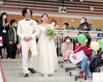 大きな拍手に包まれながら結婚式に臨む新郎新婦