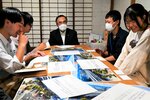 深沢市長（中央）と意見交換をする学生ら＝２３日、鳥取市元町の不真面目商店