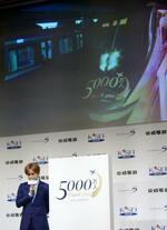 　中島健人と、成田空港駅を出発するスカイライナー（上部モニター）＝東京都港区