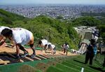 　ジャンプ台逆走レースに挑む参加者。眼下に広がる景色を楽しむ余裕はない＝２０２４年５月１８日、札幌市の大倉山ジャンプ競技場