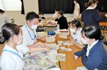  切り抜いた記事を比べて議論する受講者ら 