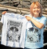 水鳥メタルＴシャツを手にする矢田さん