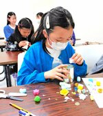 飾りを組み合わせて自分好みの缶詰を作る児童＝１９日、米子市美術館