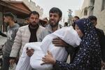 　３月２１日、ガザ北部ガザ市で、イスラエルの攻撃により殺害された１１歳の娘の遺体を運ぶ父親（ＡＰ＝共同）