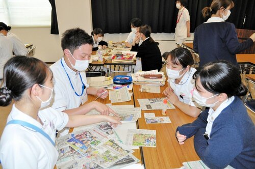  切り抜いた記事を比べて議論する受講者ら 