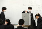 １票を投じる学生たち＝１４日、米子市彦名町