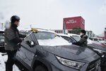 展示車両の雪おろしをするスタッフ＝22日午前11時46分、米子市両三柳のガリバーアウトレット431号米子店
