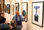 岩垣さん（右）の軽やかな作品解説に耳を傾ける参加者＝１３日、鳥取市気高町勝見の長泉寺ギャラリー