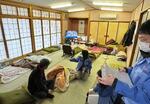 　避難所で被災者（左端）の健康調査を実施する宮城県石巻市職員＝２０２４年１月、石川県志賀町（石巻市提供）