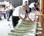 白菊を献花する参列者＝２８日、大山町末長の大山公民館