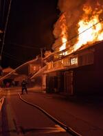 消火活動する消防関係者＝２８日午前、大山町御来屋（日本海新聞名和販売所・通信部提供）