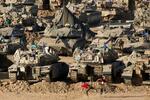 　ガザ地区との境界に近いイスラエル側に配置されたイスラエル軍の軍用車両近くでサッカーをする兵士＝２０２４年６月２日（ロイター＝共同）