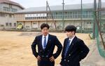 　石川県輪島市の県立輪島高で、液状化などの被害を受けたグラウンドを見つめる宮下維織さん（右）＝４日午後