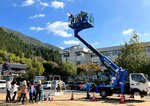 高さ１０㍍の高所作業車の乗車体験に歓声を上げる子どもたち（提供写真）