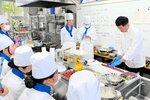 鹿肉を調理するプロの手つきに見入る生徒たち