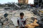 　パレスチナ自治区ガザ南部ハンユニスで、イスラエルの攻撃で破壊された建物と子ども＝２０日（ロイター＝共同）