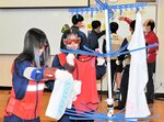 高齢者の身体機能を再現する器具を装着して洗濯物を干す生徒ら＝新温泉町芦屋の浜坂高