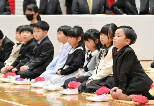 緊張した面持ちで莚の上に正座する新１年生たち＝１９日、倉吉市の西郷小
